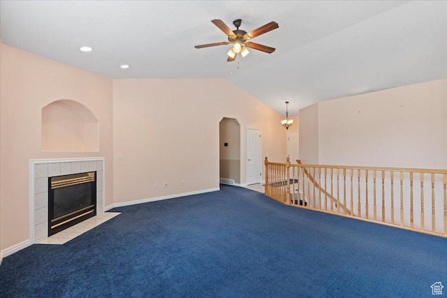 2718 W Southpointe Rd, South Jordan, UT 84095 - unfurnished living room with carpet flooring, vaulted ceiling, a tiled fireplace, a ceiling fan, and baseboards
