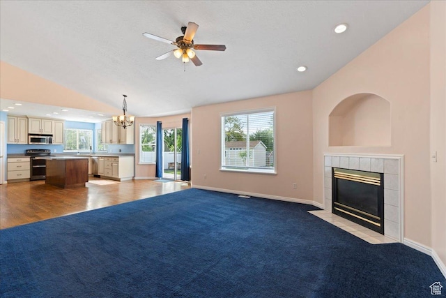 2718 W Southpointe Rd, South Jordan, UT 84095 - unfurnished living room featuring a tiled fireplace, a chandelier, ceiling fan, lofted ceiling, and light colored carpet