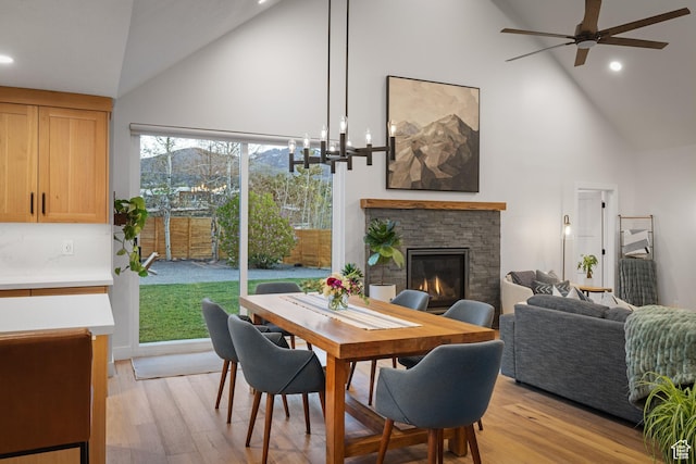 1753 Teal Dr, Kimball Junction, UT 84098 - dining area featuring high vaulted ceiling, a ceiling fan, a stone fireplace, light wood-style flooring, and recessed lighting