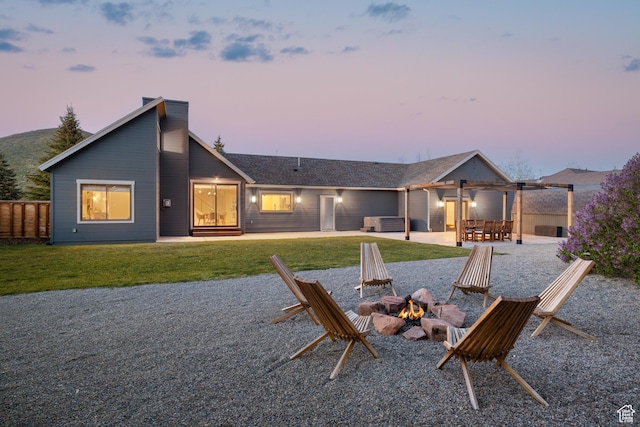 1753 Teal Dr, Kimball Junction, UT 84098 - back of house at dusk with an outdoor fire pit, a lawn, and a patio