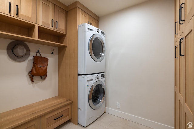 1753 Teal Dr, Kimball Junction, UT 84098 - laundry room featuring estacked washer and dryer, light tile patterned floors, baseboards, and cabinet space