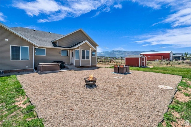 1038 S 4575 W, Cedar City, UT 84720 - rear view of house featuring an outdoor fire pit, a mountain view, and roof with shingles