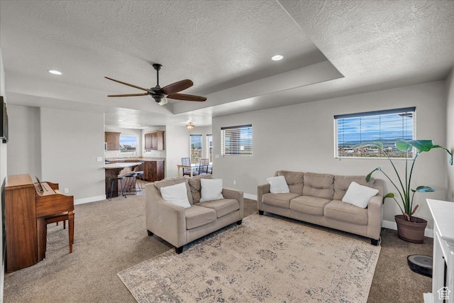 1038 S 4575 W, Cedar City, UT 84720 - living area featuring baseboards, a textured ceiling, ceiling fan, a raised ceiling, and light carpet