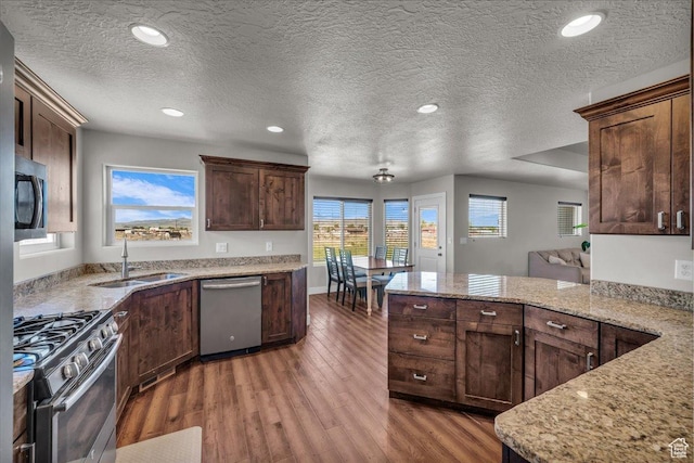 1038 S 4575 W, Cedar City, UT 84720 - kitchen with appliances with stainless steel finishes, a sink, wood finished floors, a peninsula, and a textured ceiling