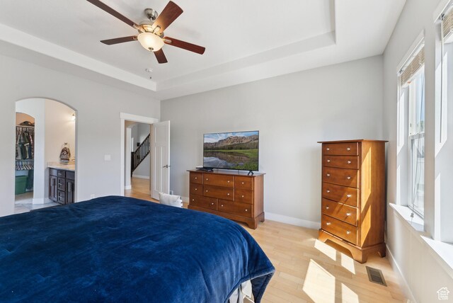 2391 S 330 E, Heber City, UT 84032 - bedroom featuring light wood finished floors, a raised ceiling, arched walkways, a ceiling fan, and baseboards