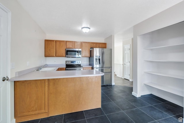5144 W Wheatcrest Cir, West Jordan, UT 84081 - kitchen featuring stainless steel appliances, a sink, light countertops, dark tile patterned floors, and a peninsula
