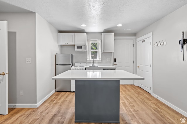1291 E 5630 S, South Ogden, UT 84403 - kitchen with light countertops, white appliances, a center island, a textured ceiling, and a sink