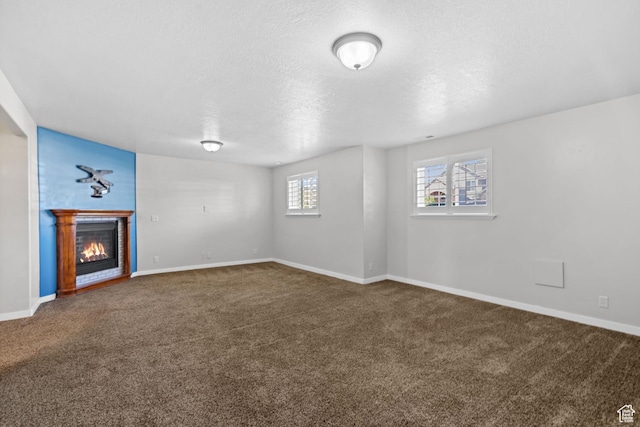 1291 E 5630 S, South Ogden, UT 84403 - unfurnished living room with carpet flooring, a glass covered fireplace, a textured ceiling, and baseboards