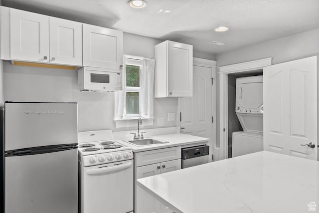 1291 E 5630 S, South Ogden, UT 84403 - kitchen with stainless steel appliances, stacked washing machine and dryer, a sink, white cabinetry, and recessed lighting