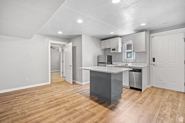 1291 E 5630 S, South Ogden, UT 84403 - kitchen with appliances with stainless steel finishes, a sink, light wood-style floors, a textured ceiling, and light countertops
