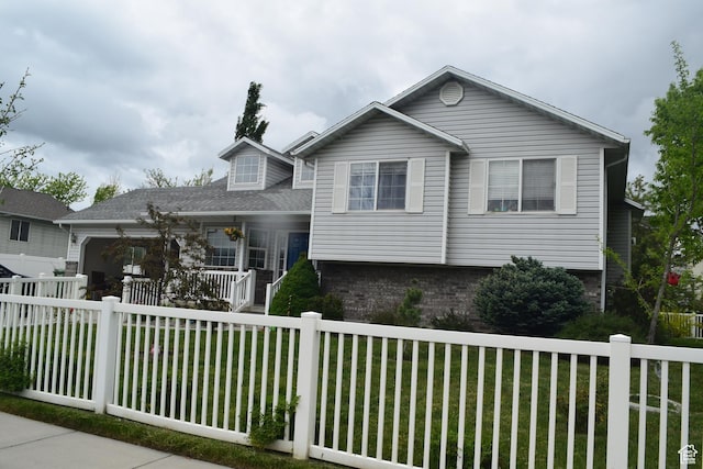 963 W Rainbow Dr, Logan, UT 84321 - tri-level home featuring a porch, brick siding, and a garage