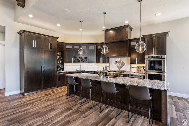 3858 E Eagle Ct, Eden, UT 84310 - kitchen featuring stainless steel appliances, baseboards, dark wood-style floors, dark brown cabinetry, and backsplash
