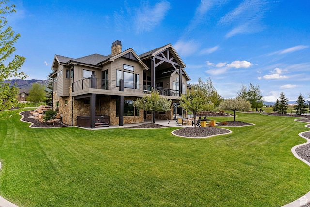 3858 E Eagle Ct, Eden, UT 84310 - back of house featuring a hot tub, a patio area, stone siding, a lawn, and a chimney
