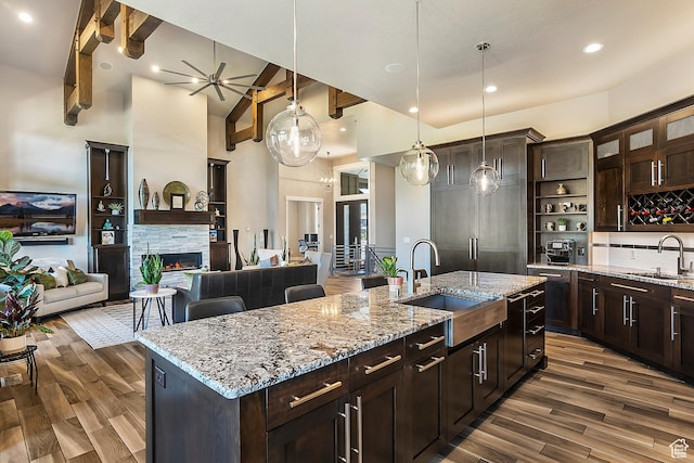 3858 E Eagle Ct, Eden, UT 84310 - kitchen featuring a sink, dark wood-type flooring, high vaulted ceiling, a kitchen island with sink, and hanging light fixtures