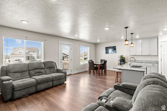 3932 S Sennie Dr W, Magna, UT 84044 - living area with wood-type flooring, a textured ceiling, recessed lighting, and baseboards