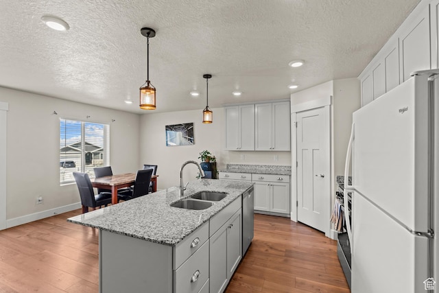 3932 S Sennie Dr W, Magna, UT 84044 - kitchen with freestanding refrigerator, a sink, stainless steel dishwasher, a textured ceiling, and recessed lighting
