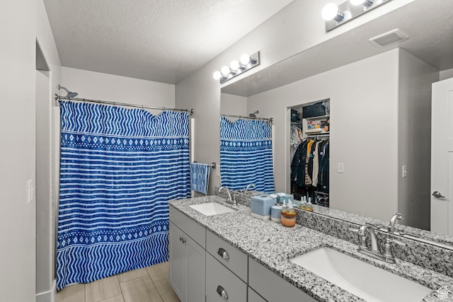 3932 S Sennie Dr W, Magna, UT 84044 - full bath featuring double vanity, a textured ceiling, curtained shower, and a walk in closet