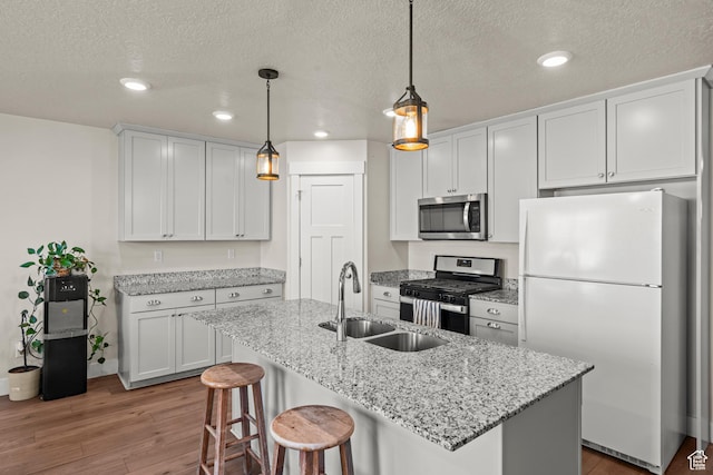 3932 S Sennie Dr W, Magna, UT 84044 - kitchen featuring appliances with stainless steel finishes, a sink, recessed lighting, wood finished floors, and a textured ceiling