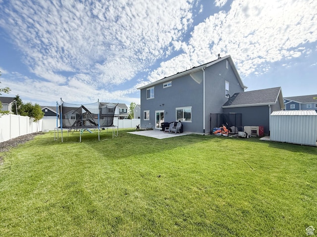 3508 S Creek Side Ln, Syracuse, UT 84075 - back of property with a trampoline, a patio area, stucco siding, and a residential view