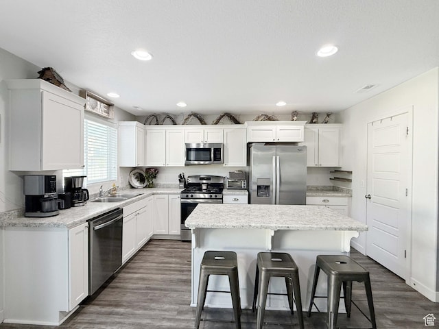 3508 S Creek Side Ln, Syracuse, UT 84075 - kitchen featuring appliances with stainless steel finishes, a breakfast bar, a kitchen island, white cabinets, and recessed lighting