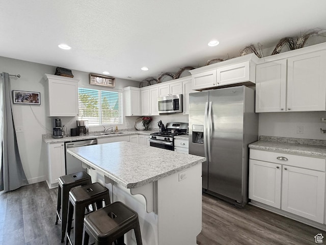 3508 S Creek Side Ln, Syracuse, UT 84075 - kitchen featuring appliances with stainless steel finishes, a sink, a kitchen breakfast bar, white cabinetry, and light countertops