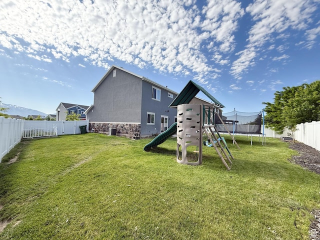 3508 S Creek Side Ln, Syracuse, UT 84075 - back of house featuring a trampoline, stone siding, and a playground