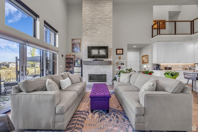 9984 N Rail Loop Unit 29, Heber City, UT 84032 - living room with a high ceiling, a stone fireplace, and wood finished floors