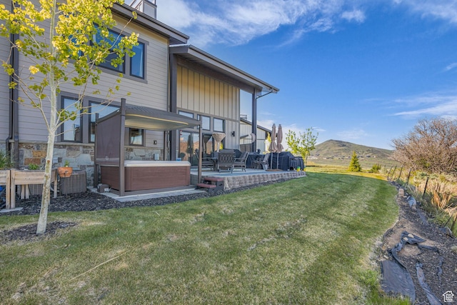 9984 N Rail Loop Unit 29, Heber City, UT 84032 - rear view of house with a hot tub, a patio, a lawn, and a mountain view