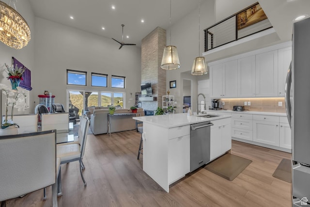 9984 N Rail Loop Unit 29, Heber City, UT 84032 - kitchen featuring stainless steel appliances, a sink, a towering ceiling, open floor plan, and a kitchen island with sink