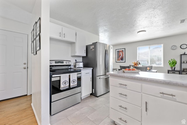 180 W Vine St, Tooele, UT 84074 - kitchen with stainless steel appliances, light countertops, white cabinets, and a textured ceiling