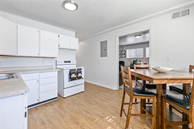 180 W Vine St, Tooele, UT 84074 - kitchen featuring white range with electric cooktop, electric panel, light countertops, light wood-style floors, and white cabinetry