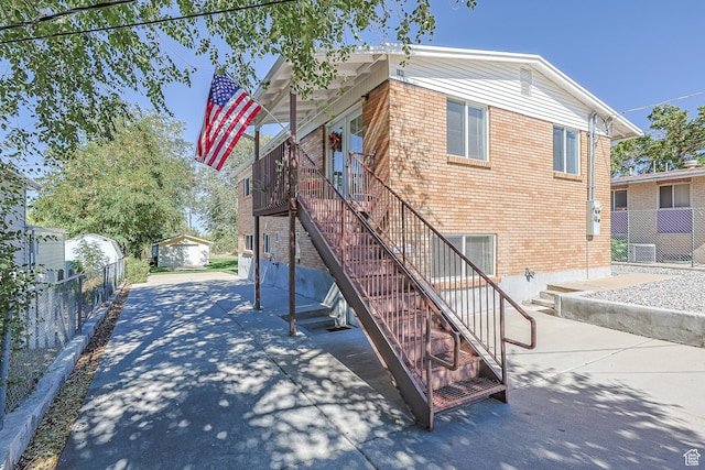 180 W Vine St, Tooele, UT 84074 - view of home's exterior with brick siding, stairs, and central AC unit