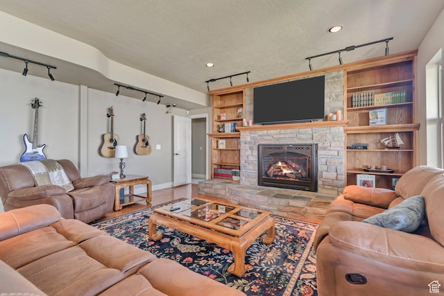 2116 E Falcon Ridge Dr, Draper Ut Cnty, UT 84020 - living room with track lighting, baseboards, and a stone fireplace