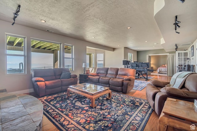 2116 E Falcon Ridge Dr, Draper Ut Cnty, UT 84020 - living room with wood finished floors, a textured ceiling, track lighting, recessed lighting, and baseboards