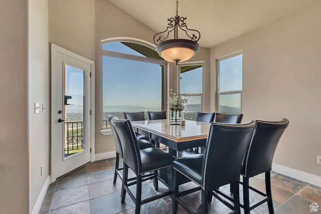 2116 E Falcon Ridge Dr, Draper Ut Cnty, UT 84020 - dining room featuring baseboards, stone tile flooring, and vaulted ceiling