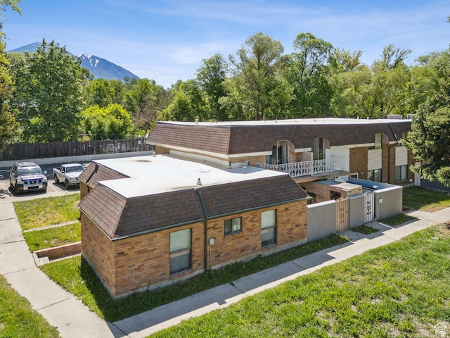 1404 N Lancelot Dr W, Provo, UT 84601 - view of front facade with a shingled roof, a mountain view, and brick siding