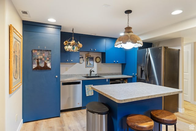 300 E 400 S, Kamas, UT 84036 - kitchen with appliances with stainless steel finishes, blue cabinetry, a sink, light countertops, and a breakfast bar
