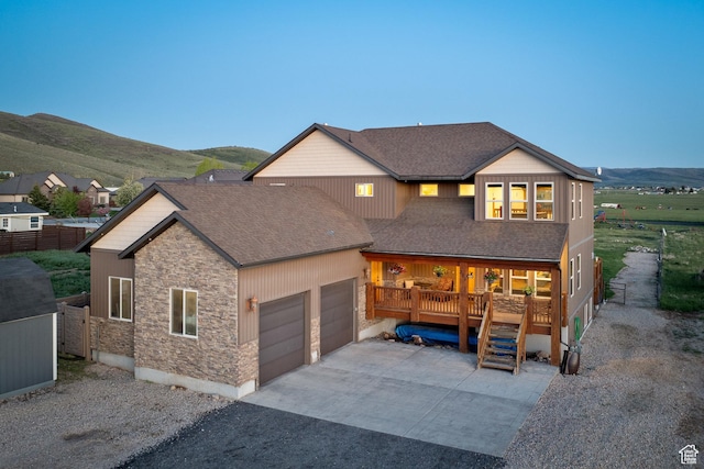 300 E 400 S, Kamas, UT 84036 - view of front of house with stone siding, roof with shingles, a garage, and covered porch