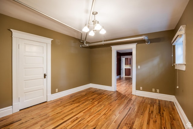 216 B St, Salt Lake City, UT 84103 - spare room with wood finished floors, a chandelier, and baseboards