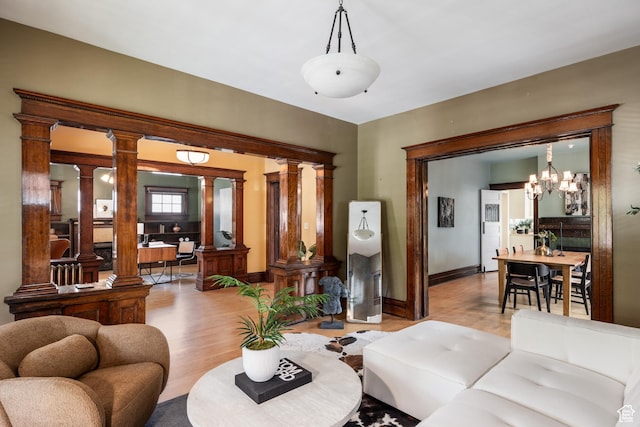 216 B St, Salt Lake City, UT 84103 - living room featuring wood finished floors, ornate columns, baseboards, and a chandelier