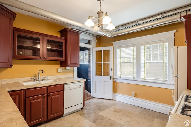 216 B St, Salt Lake City, UT 84103 - kitchen with white appliances, a sink, light countertops, a chandelier, and glass insert cabinets