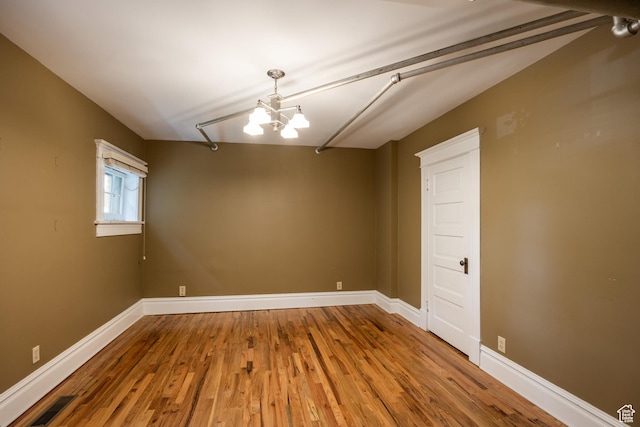 216 B St, Salt Lake City, UT 84103 - empty room featuring a chandelier, wood finished floors, and baseboards