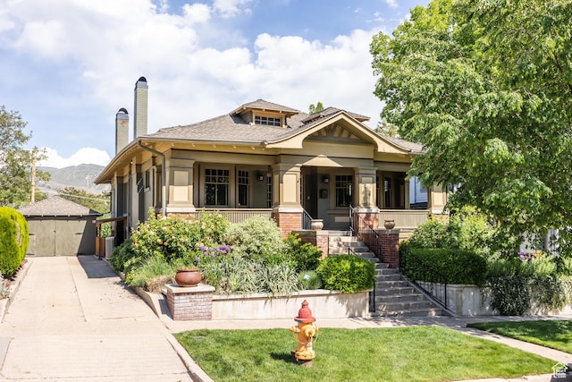 216 B St, Salt Lake City, UT 84103 - view of front of property featuring stairway, a porch, a chimney, a front lawn, and an outbuilding