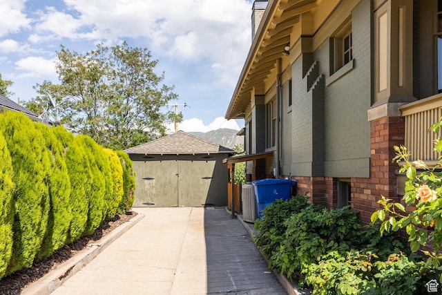 216 B St, Salt Lake City, UT 84103 - view of home's exterior featuring brick siding, an outdoor structure, and a chimney