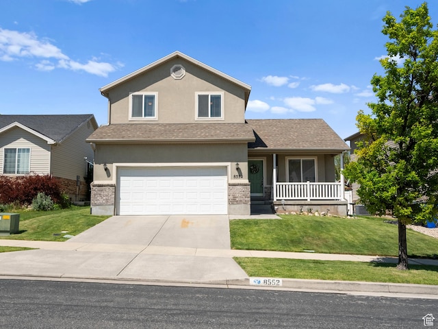 8552 S Maul Oak Dr, West Jordan, UT 84081 - view of front of property with covered porch, concrete driveway, a front lawn, and stucco siding