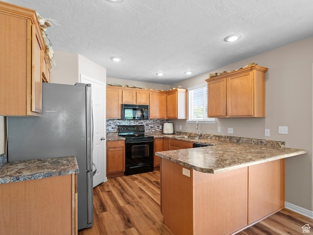 8552 S Maul Oak Dr, West Jordan, UT 84081 - kitchen with black appliances, a peninsula, a sink, light wood-style floors, and a textured ceiling