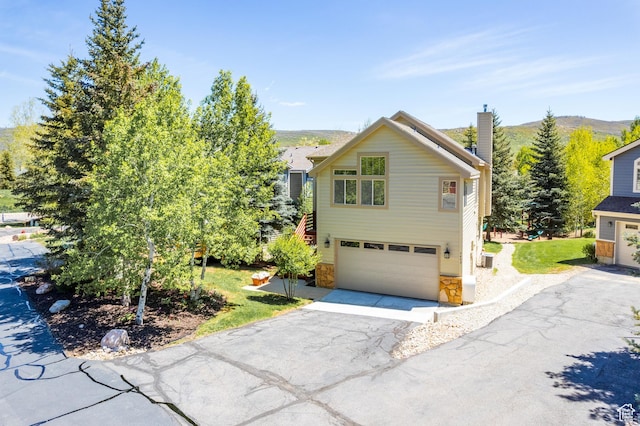 7403 Brook Hollow Loop Rd, Park City, UT 84098 - traditional home featuring an attached garage, driveway, stone siding, a chimney, and a front lawn