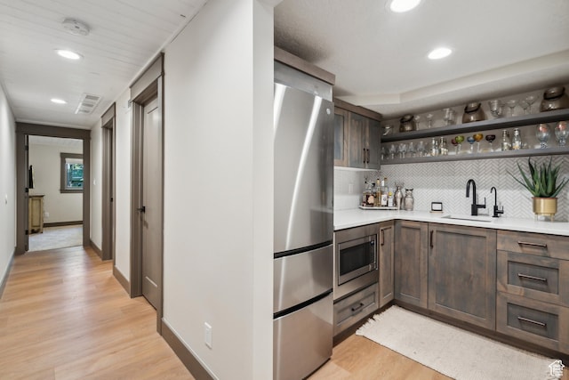 3058 Elk Run Dr W, Park City, UT 84098 - indoor wet bar featuring appliances with stainless steel finishes, light wood finished floors, backsplash, and recessed lighting