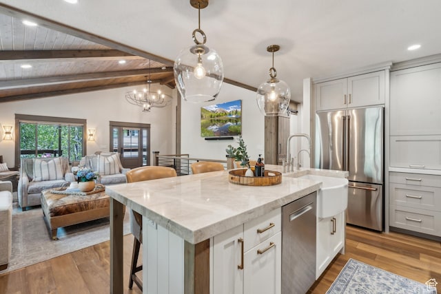 3058 Elk Run Dr W, Park City, UT 84098 - kitchen featuring stainless steel appliances, a kitchen island with sink, light wood-style floors, open floor plan, and light stone countertops