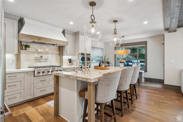 3058 Elk Run Dr W, Park City, UT 84098 - kitchen with appliances with stainless steel finishes, custom range hood, decorative backsplash, light wood-type flooring, and an island with sink